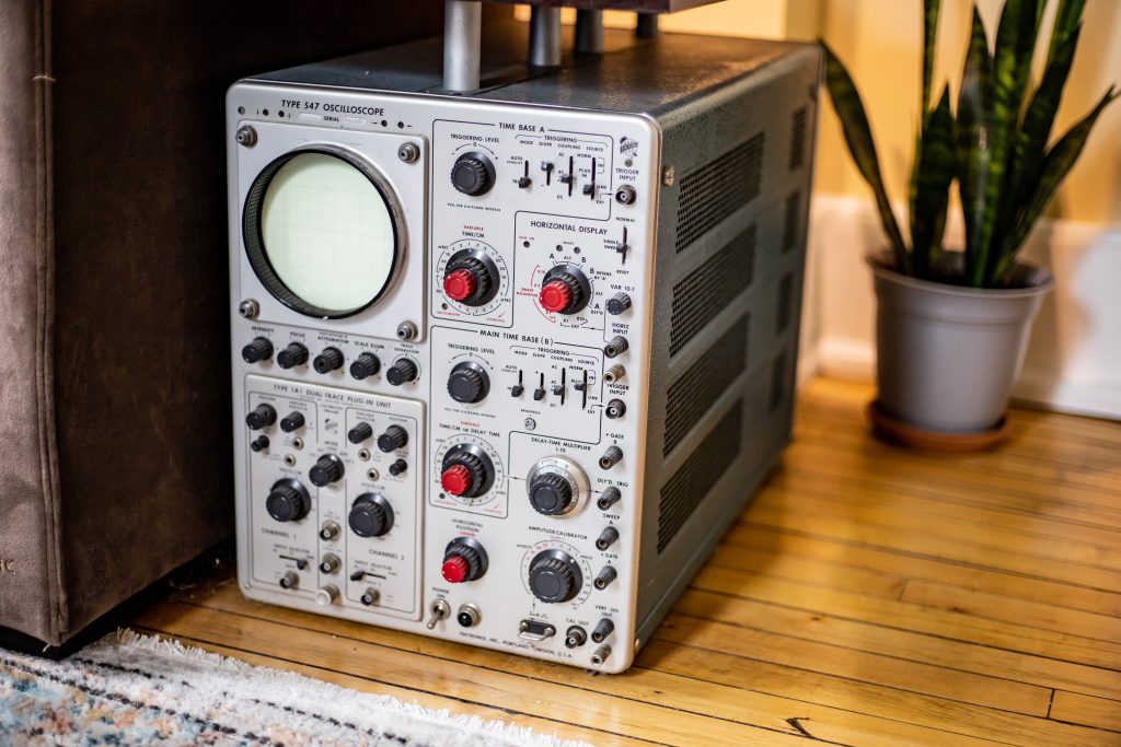 Tektronix type 547 oscilloscope on a wooden floor with a plant in the background