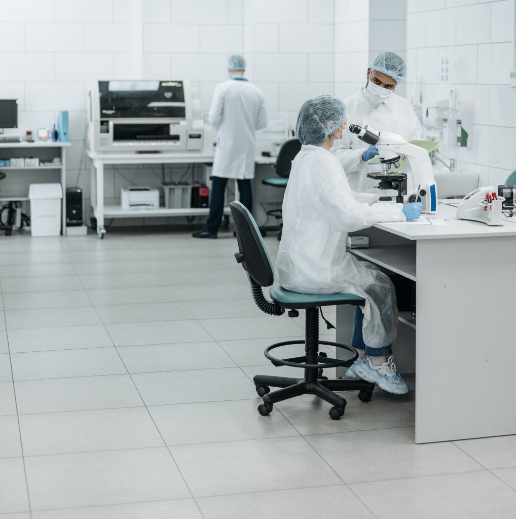 Scientists wearing white lab coats in a white lab