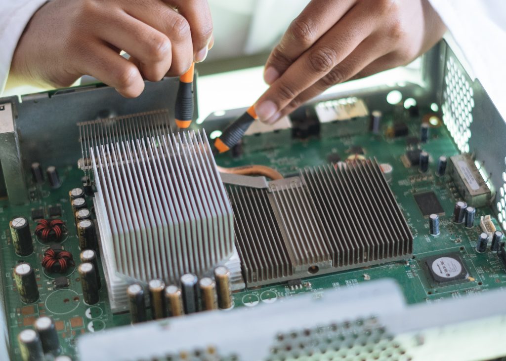 Closeup of scientist testing a green circuit board