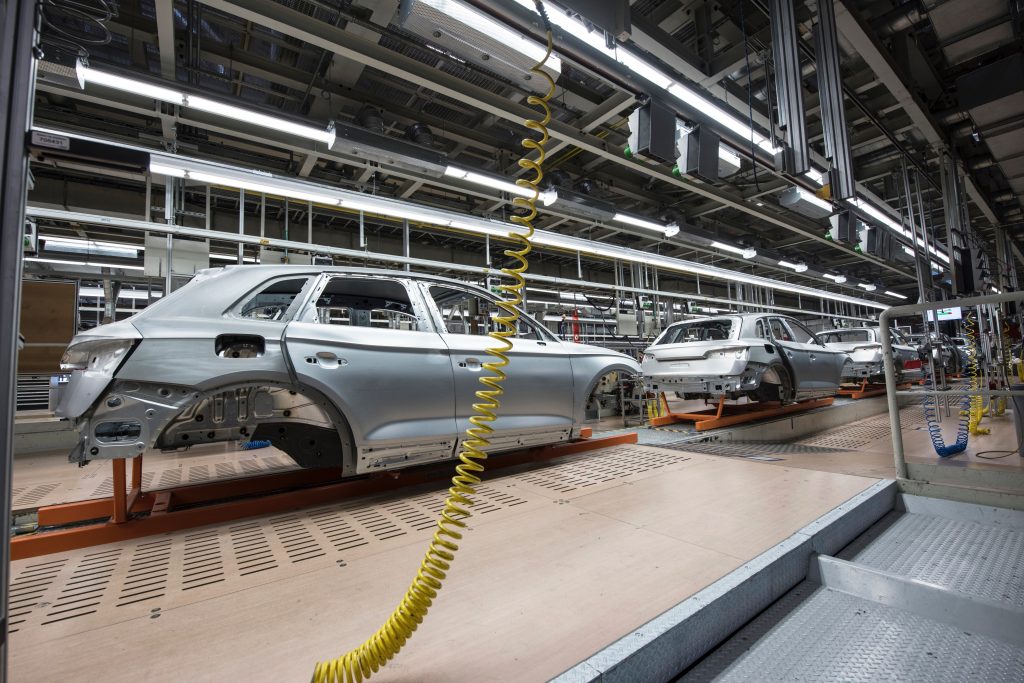 White cars in an assembly line in a factory