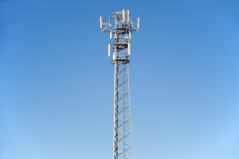 Tall white broadcast tower against a blue sky